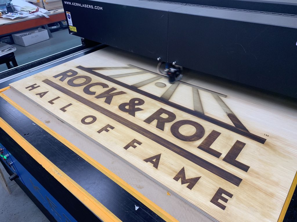 Laser engraving the Rock and Roll Hall of Fame logo into a wood panel